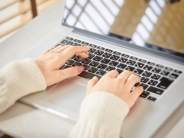 ノートパソコンを使う女性、タイピング