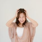 頭を抱えて悩む女性