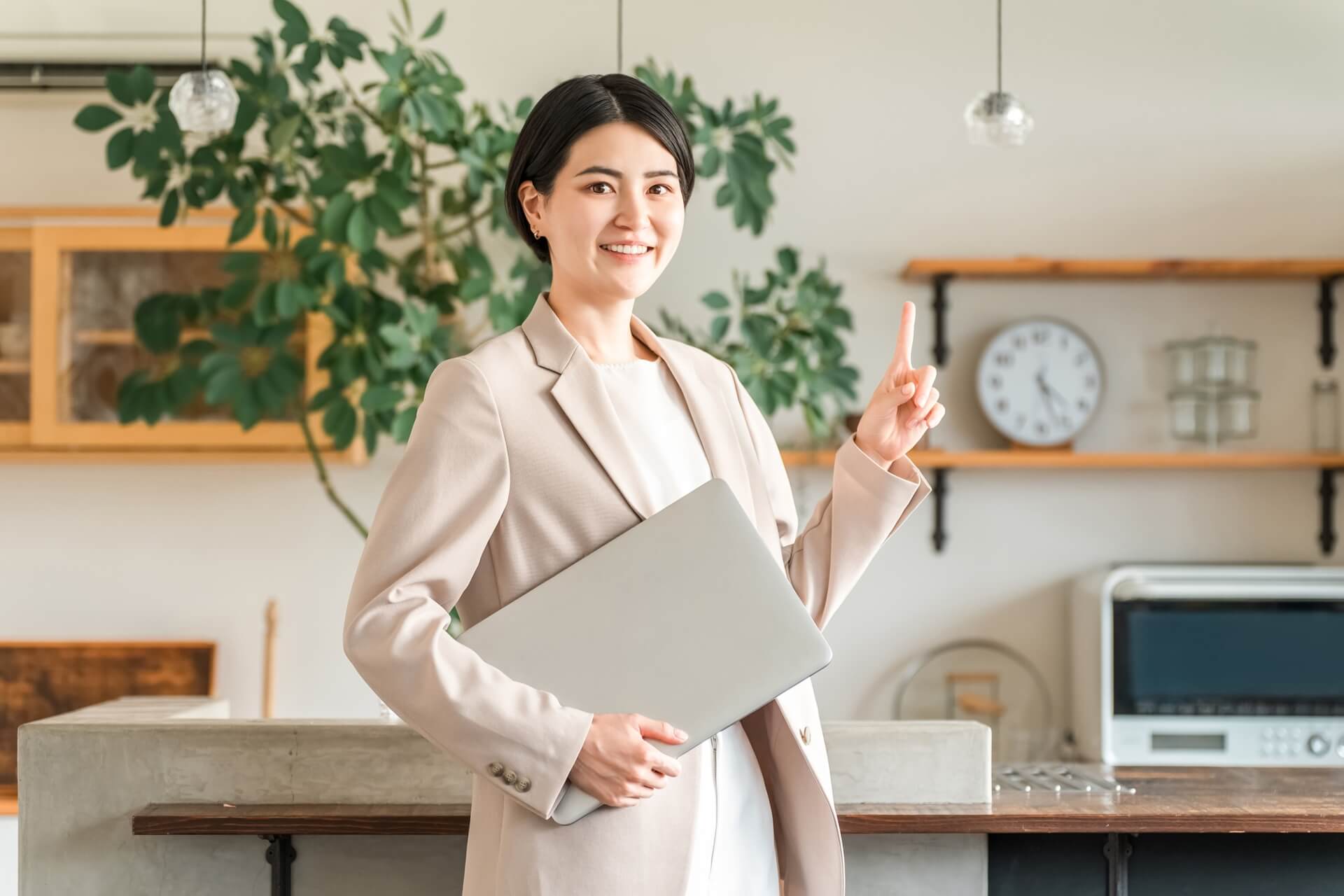 ノートPCを以て人差し指を立てる女性、オフィス