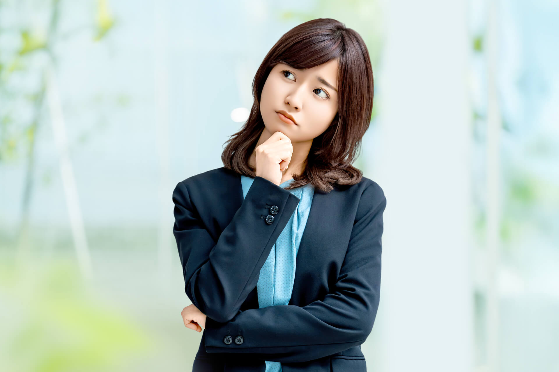 小首をかしげる困った顔のスーツ姿の女性、OL、困る